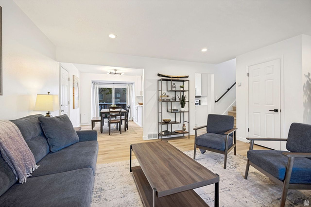 1723 Albury Road Sandy, UT 84092 - Photo 6 of 23 Open-concept living area featuring light wood-finish flooring, recessed lighting, white trim, and a sliding glass door leading to an outdoor space