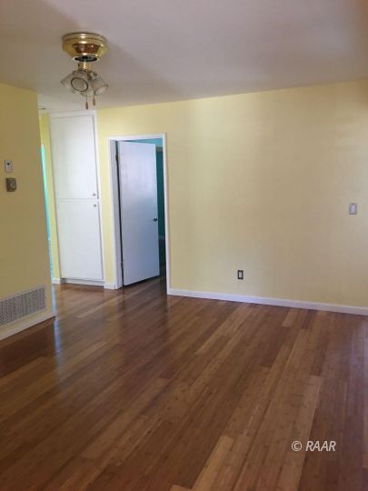 224 West Rader Avenue Ridgecrest, CA 93555 - Photo 7 of 26 an empty room with wooden floor and a ceiling fan