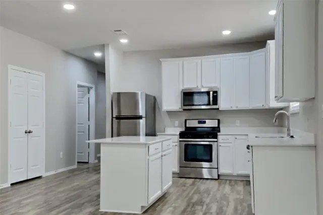 a kitchen with cabinets and stainless steel appliances