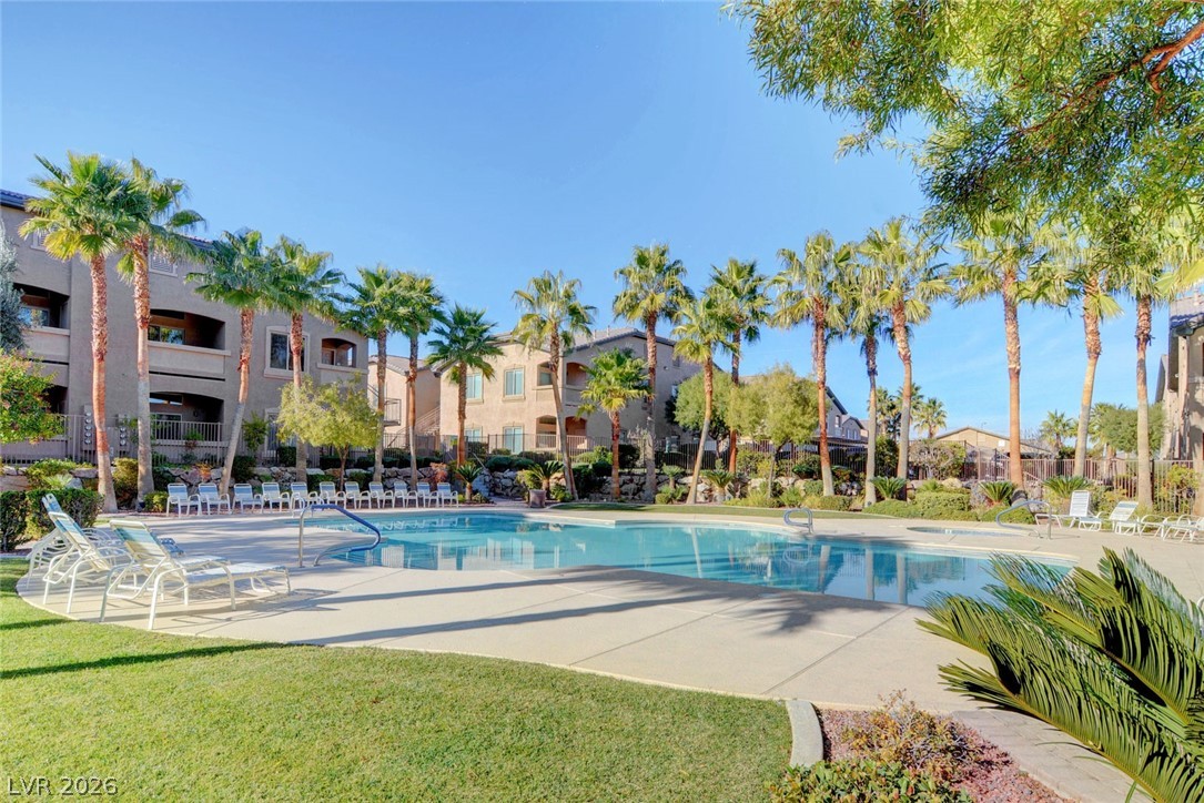 8985 South Durango Drive, Unit 2187 Las Vegas, NV 89113 - Photo 65 of 73 An inviting community pool surrounded by palm trees and apartment homes offers a refreshing retreat.