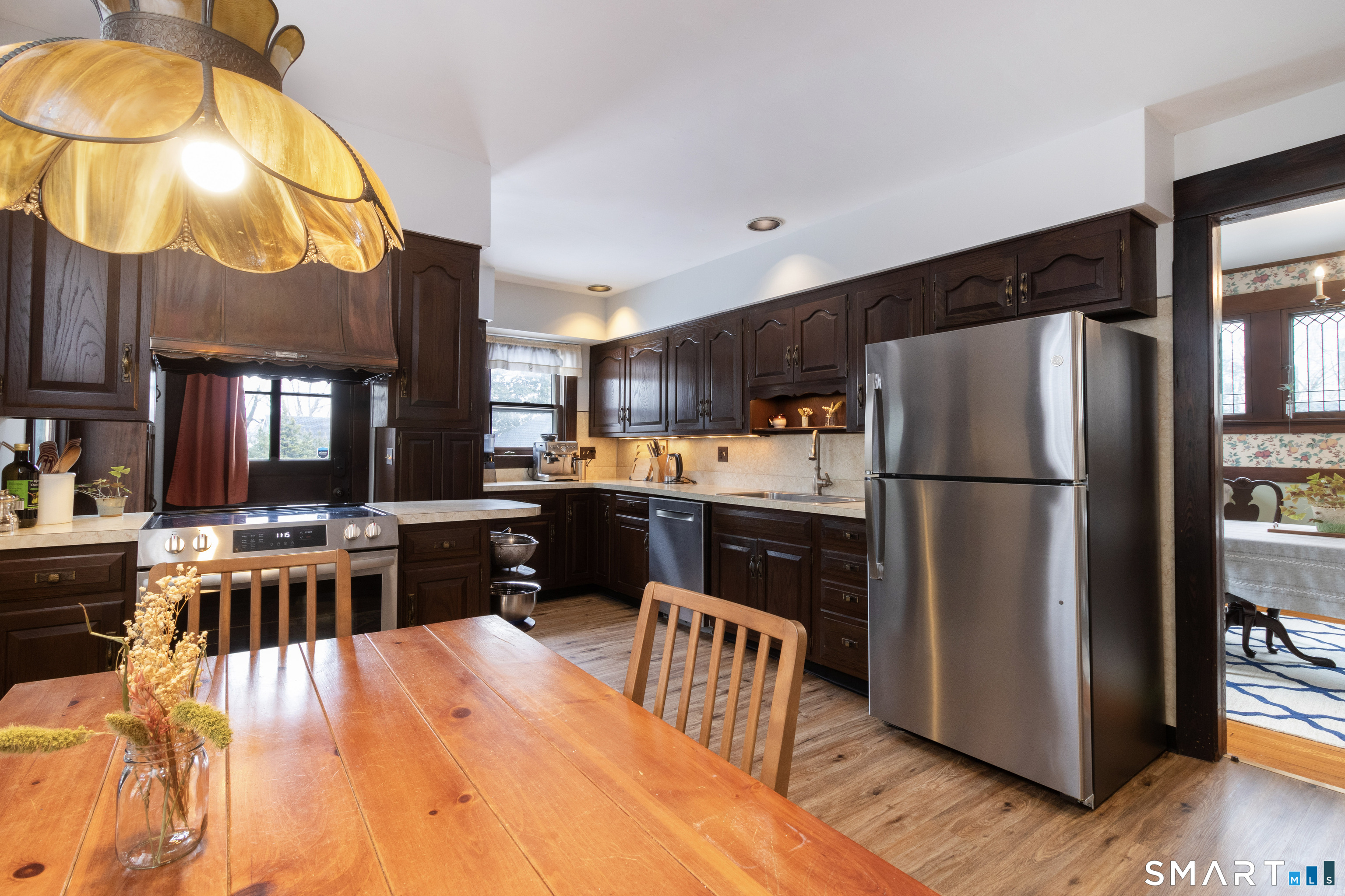 319 South Main Street Wallingford, CT 06492 - Photo 18 of 37 a kitchen with stainless steel appliances a stove a refrigerator a sink a dining table and chairs with wooden floor