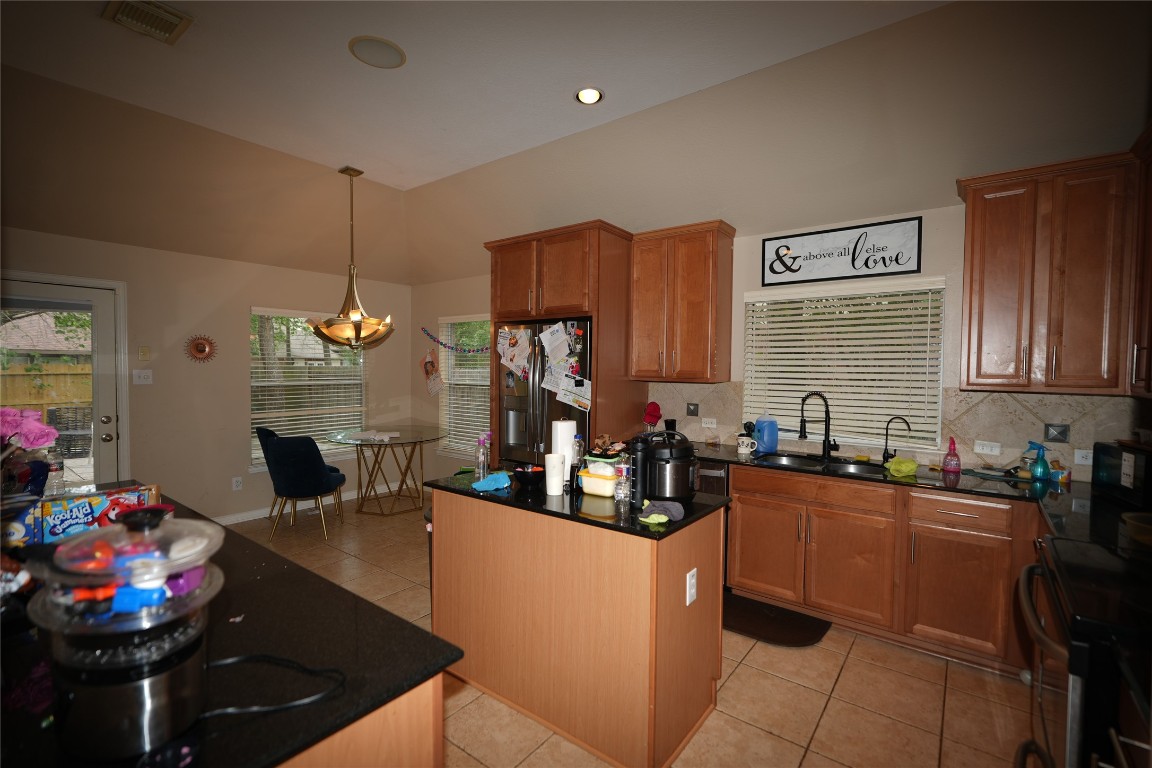 12711 Big Spring Trail Humble, TX 77346 - Photo 11 of 25 a kitchen with sink refrigerator dining table and chairs
