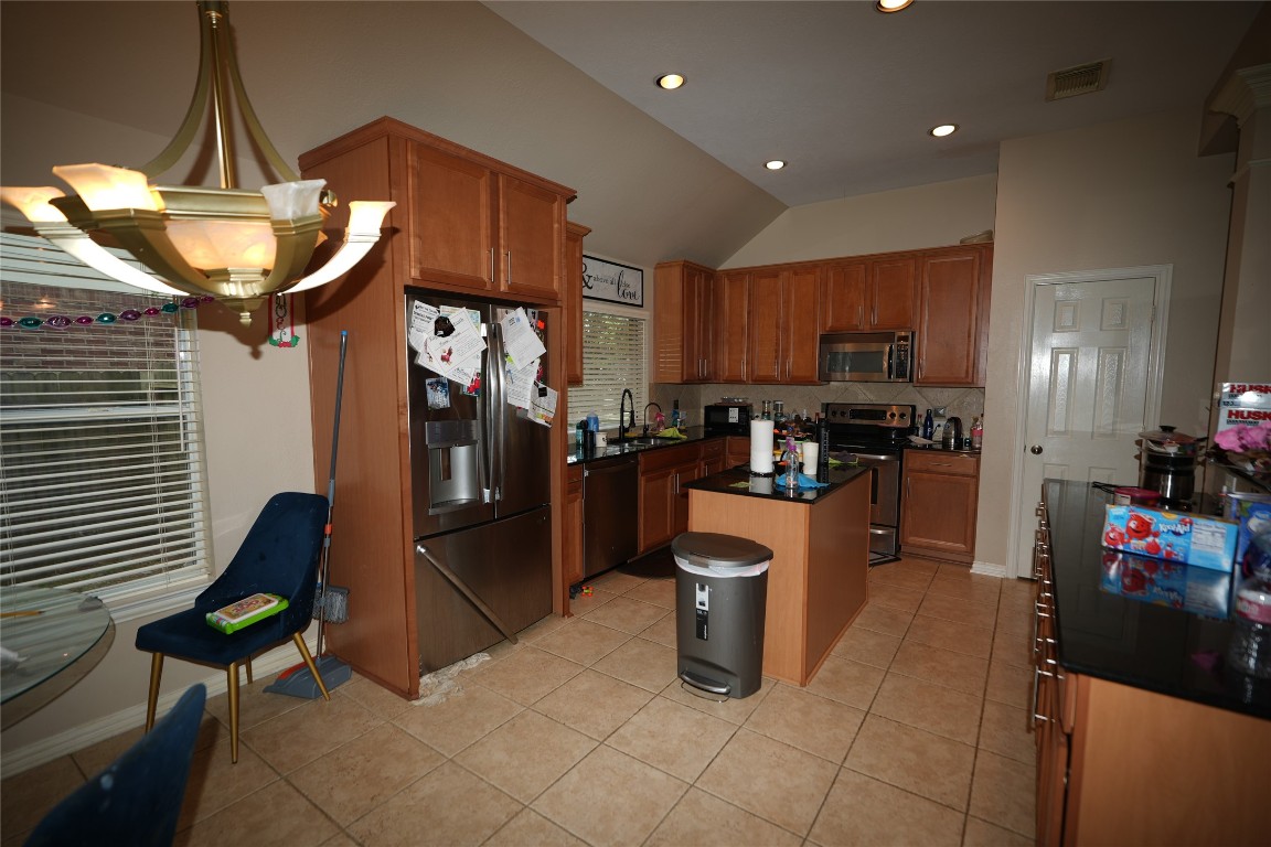 12711 Big Spring Trail Humble, TX 77346 - Photo 13 of 25 a kitchen with refrigerator and chairs