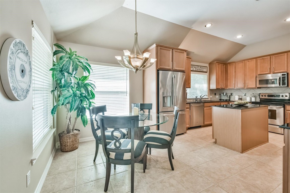 12711 Big Spring Trail Humble, TX 77346 - Photo 14 of 25 a kitchen with stainless steel appliances a table chairs and a refrigerator