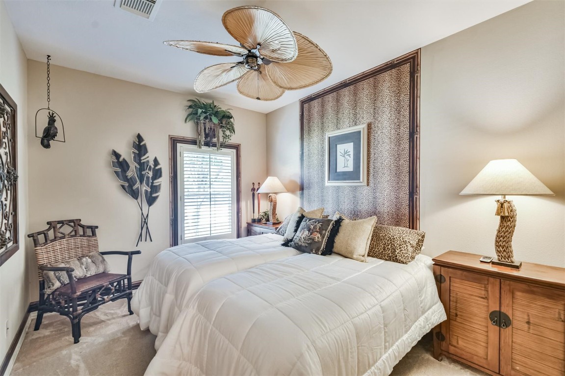 12711 Big Spring Trail Humble, TX 77346 - Photo 19 of 25 a bedroom with a bed and a chandelier
