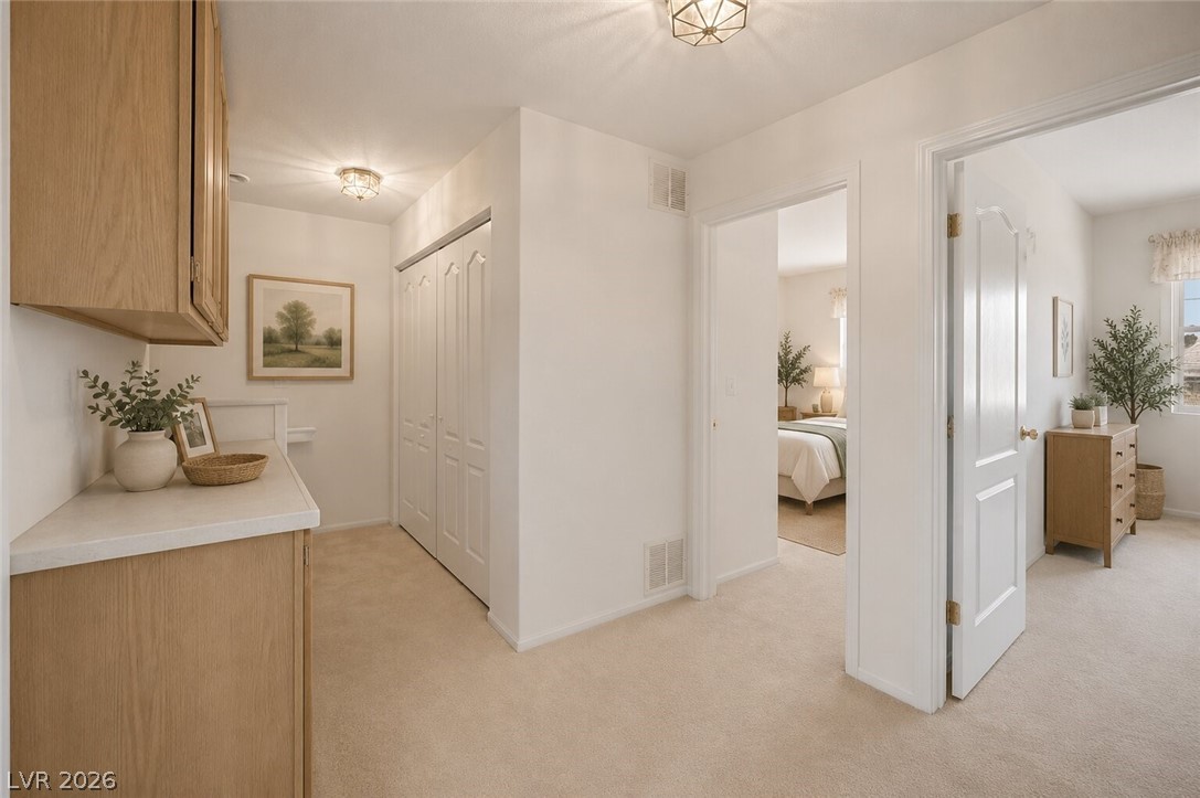 2243 Rugged Mesa Drive Laughlin, NV 89029 - Photo 14 of 32 Hallway leading to inviting bedrooms, featuring practical storage and neutral decor.