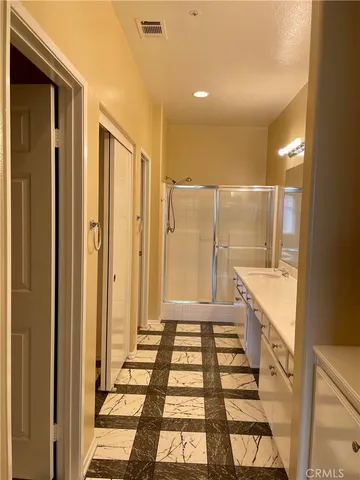 a bathroom with a glass door shower and a sink