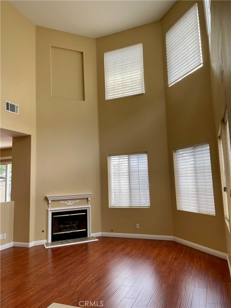 149 Islington Irvine, CA 92620 - Photo 5 of 15 an empty room with wooden floor fireplace and windows