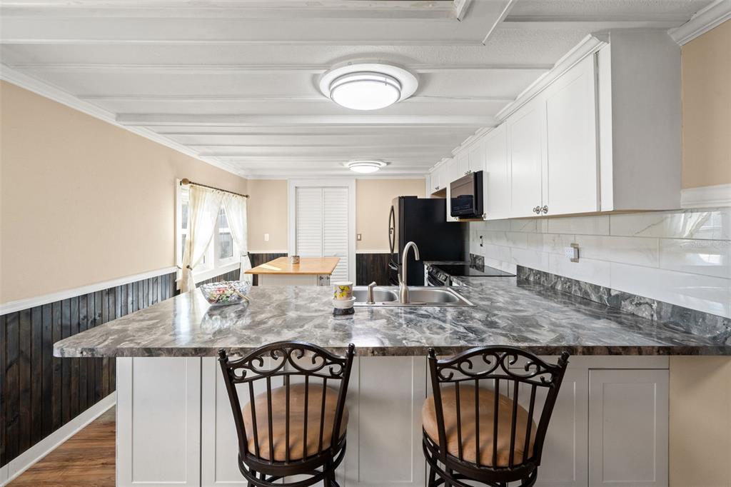 7288 Coventry Court Weeki Wachee, FL 34607 - Photo 11 of 82 a kitchen with stainless steel appliances granite countertop a stove a sink dishwasher a microwave oven with granite countertops and cabinets