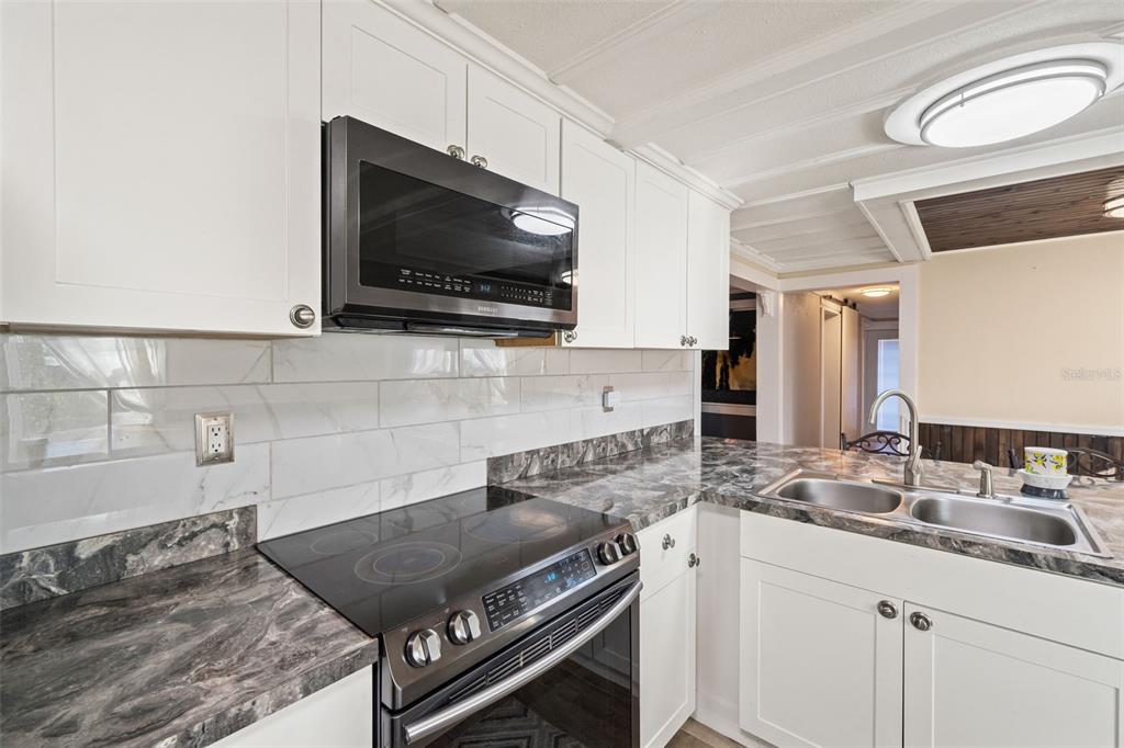 7288 Coventry Court Weeki Wachee, FL 34607 - Photo 16 of 82 a kitchen with a stove and a microwave