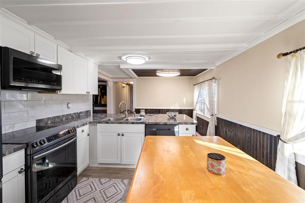 7288 Coventry Court Weeki Wachee, FL 34607 - Photo 18 of 82 a kitchen with sink a stove and microwave