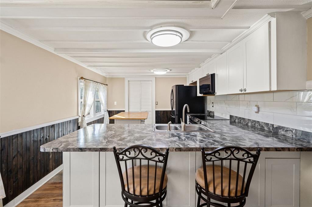7288 Coventry Court Weeki Wachee, FL 34607 - Photo 33 of 82 a kitchen with stainless steel appliances granite countertop a stove a sink a microwave and a refrigerator