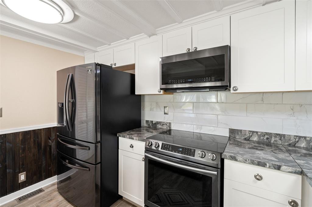 7288 Coventry Court Weeki Wachee, FL 34607 - Photo 37 of 82 a kitchen with a stove microwave and refrigerator