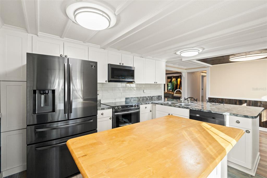 7288 Coventry Court Weeki Wachee, FL 34607 - Photo 40 of 82 a kitchen with a refrigerator a stove top oven and a sink
