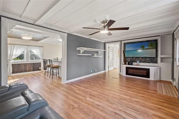 a view of an empty room with window and wooden floor