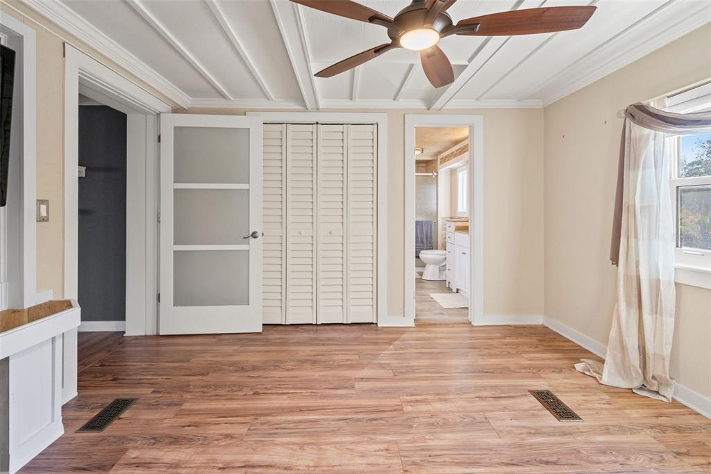 7288 Coventry Court Weeki Wachee, FL 34607 - Photo 7 of 82 a view of an empty room with wooden floor and a window
