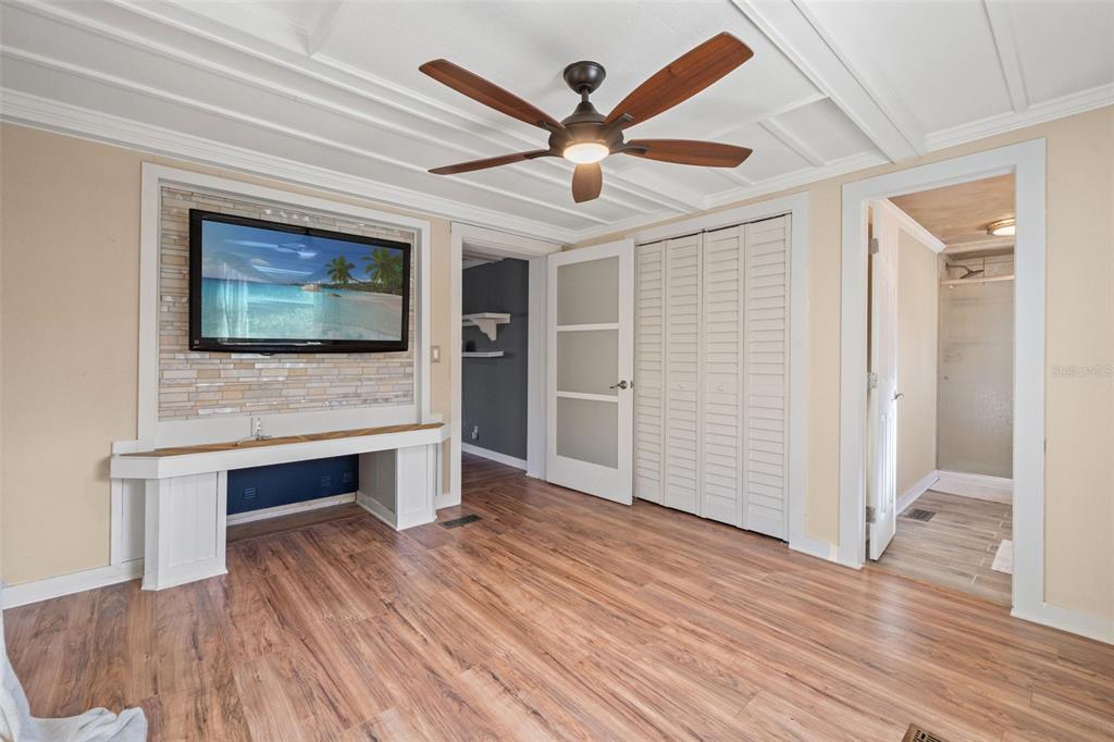 7288 Coventry Court Weeki Wachee, FL 34607 - Photo 9 of 82 a view of an empty room with wooden floor and a ceiling fan