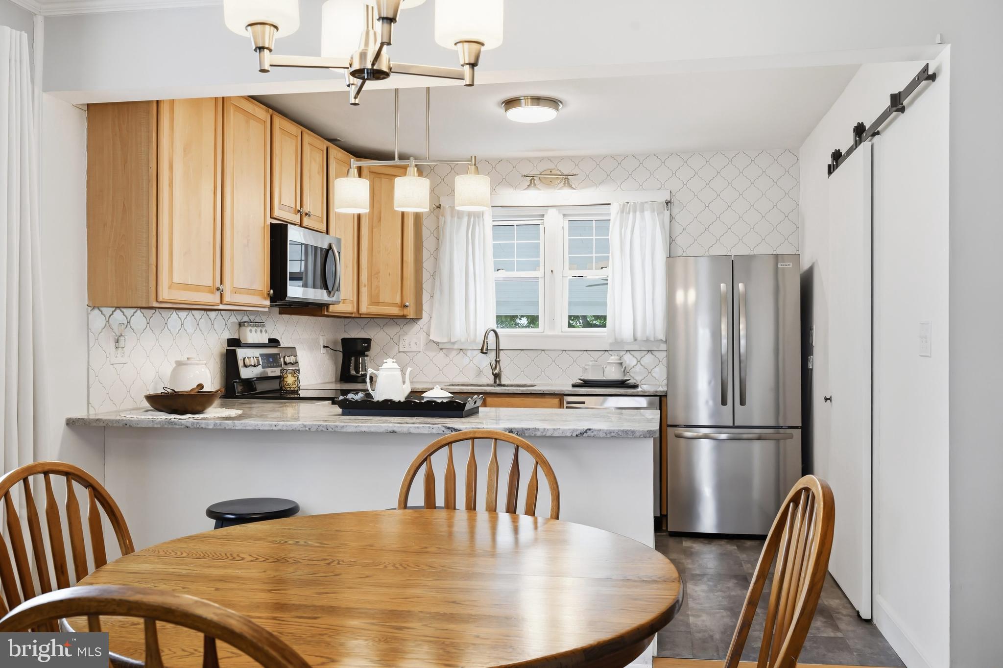 207 Crusader Road Cambridge, MD 21613 - Photo 25 of 76 a kitchen with stainless steel appliances granite countertop a refrigerator a sink a stove and dishwasher with wooden floor
