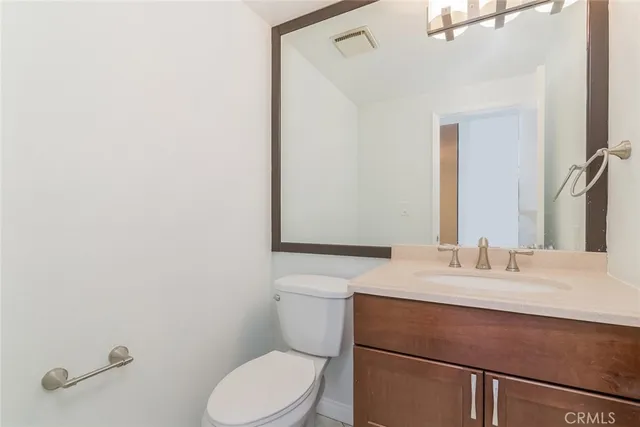 a bathroom with a sink vanity mirror and toilet