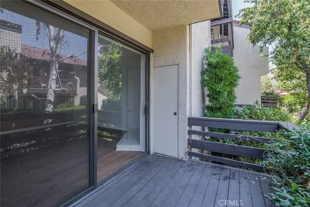 a view of a wooden bench in front of a glass door