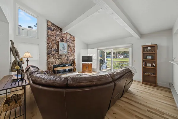 a large kitchen with a table chairs wooden cabinets and wooden floor
