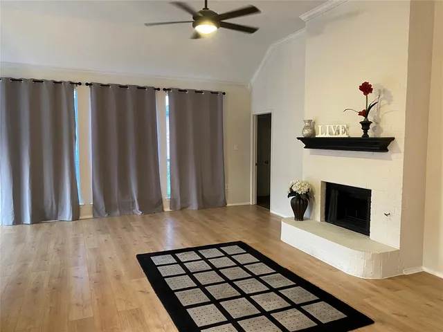 a view of a livingroom with wooden floor and a fireplace