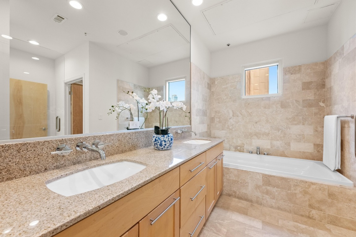 1600 Barton Springs Road, Unit 5601 Austin, TX 78704 - Photo 20 of 36 a bathroom with a granite countertop sink mirror and bathtub