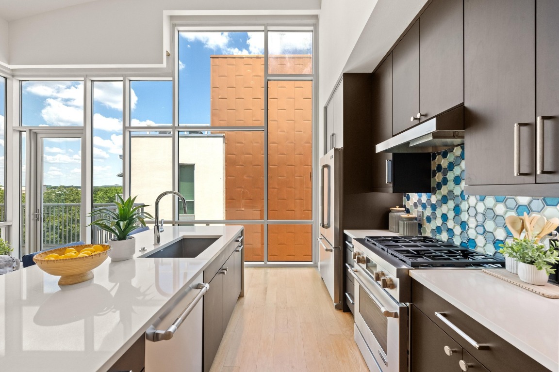 1600 Barton Springs Road, Unit 5601 Austin, TX 78704 - Photo 3 of 36 This stylish kitchen features an oversized center island with waterfall edge, quartz countertops, Jenn-Air stainless steel appliances.