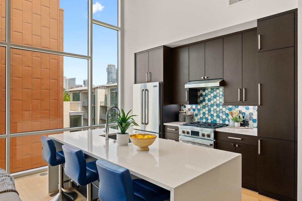 1600 Barton Springs Road, Unit 5601 Austin, TX 78704 - Photo 9 of 36 a kitchen with stainless steel appliances a dining table chairs and refrigerator