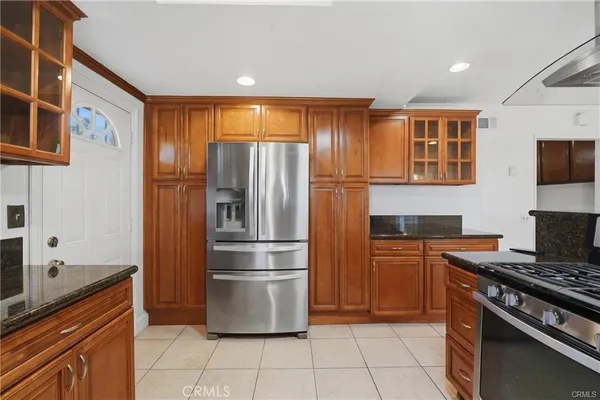 a kitchen with granite countertop a refrigerator and a stove top oven