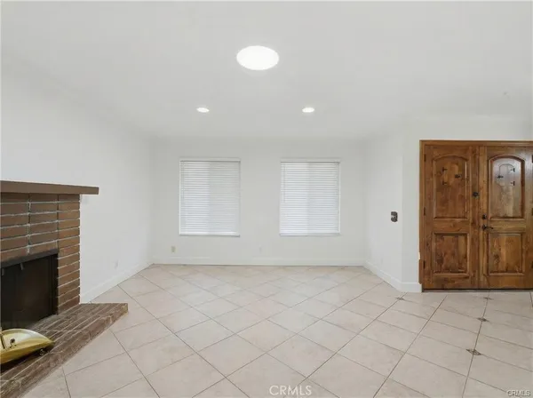 an empty room with windows and fireplace
