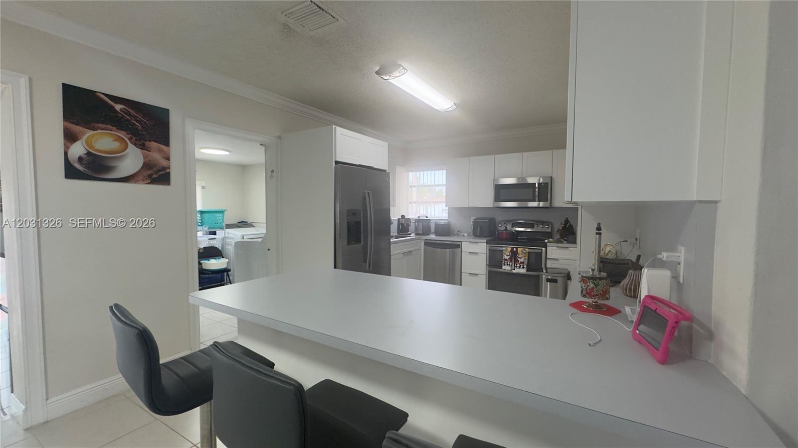 12480 Southwest 189th Street Miami, FL 33177 - Photo 7 of 25 a kitchen with stainless steel appliances a refrigerator a sink a stove and white cabinets