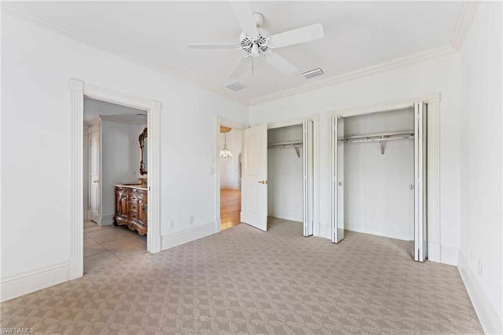 7126 Mill Run Road Naples, FL 34109 - Photo 23 of 49 Unfurnished bedroom with ceiling fan, crown molding, light carpet, and two closets