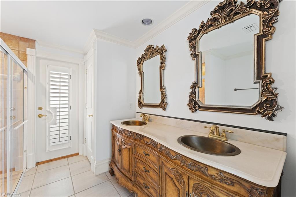 7126 Mill Run Road Naples, FL 34109 - Photo 25 of 49 Bathroom featuring tile patterned floors, crown molding, vanity, and walk in shower