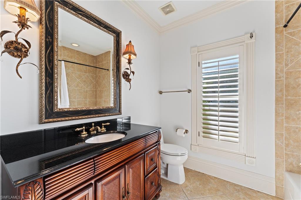 7126 Mill Run Road Naples, FL 34109 - Photo 27 of 49 Full bathroom featuring vanity, tiled shower / bath, tile patterned flooring, toilet, and ornamental molding