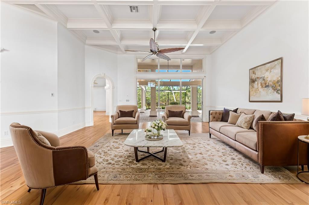 7126 Mill Run Road Naples, FL 34109 - Photo 3 of 49 Living room with beam ceiling, light hardwood / wood-style flooring, ceiling fan, and coffered ceiling