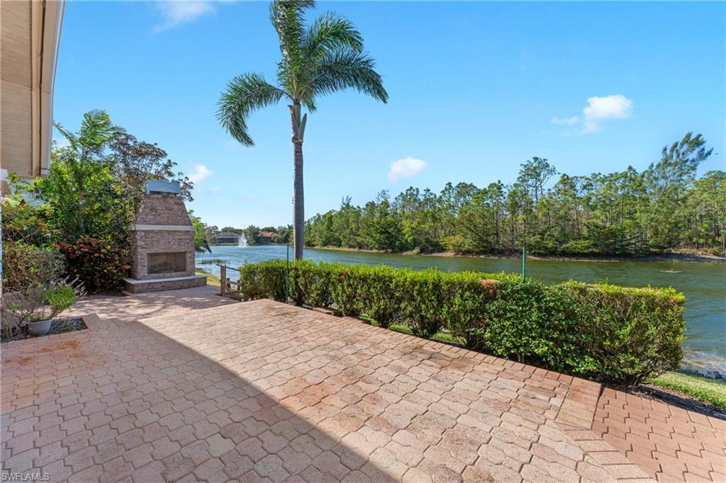 7126 Mill Run Road Naples, FL 34109 - Photo 38 of 49 View of patio / terrace featuring an outdoor stone fireplace and a water view