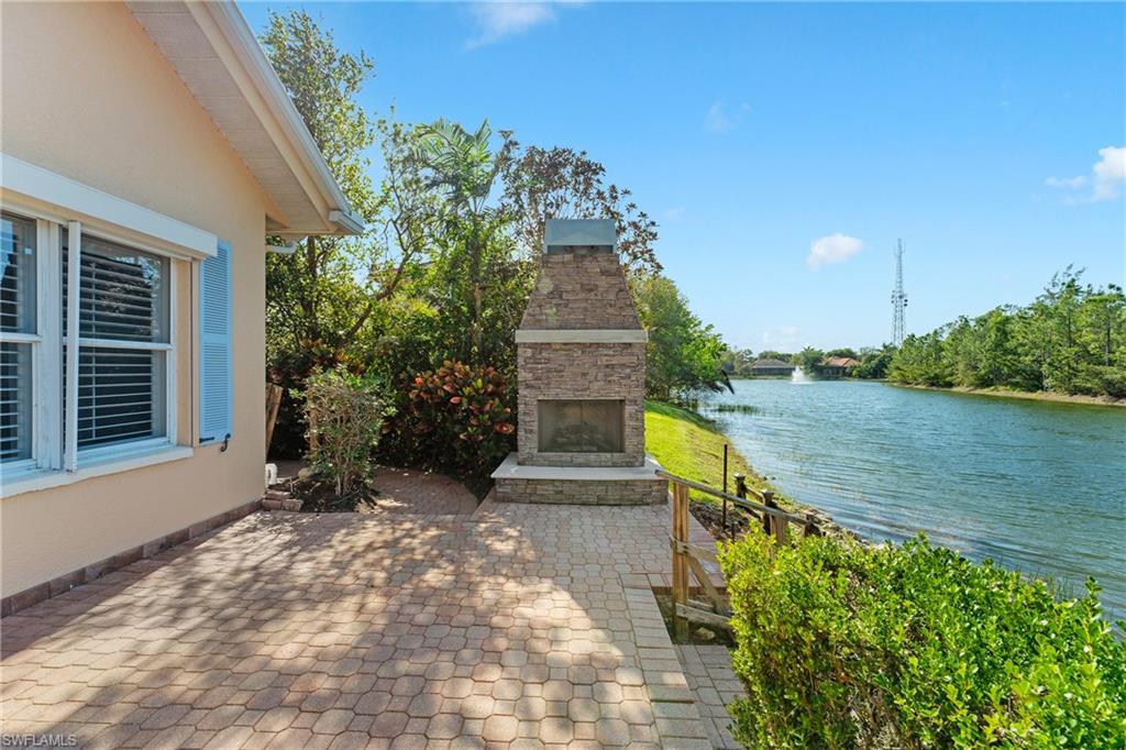 7126 Mill Run Road Naples, FL 34109 - Photo 39 of 49 View of patio with an outdoor stone fireplace and a water view