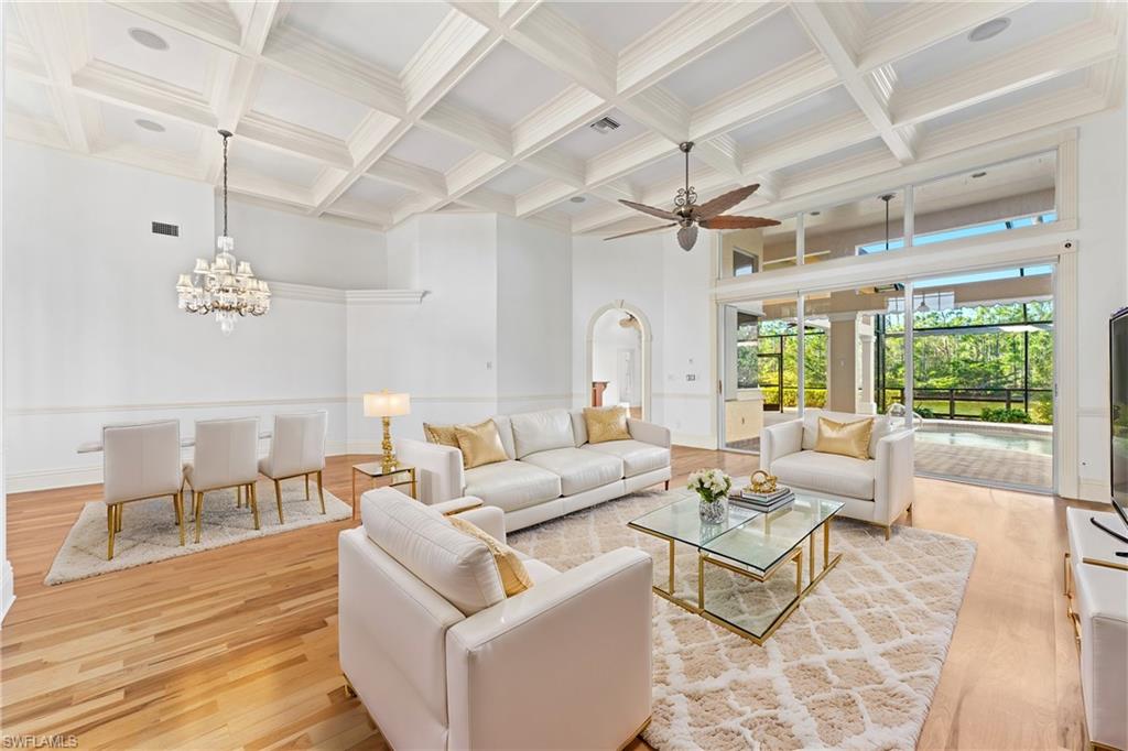 7126 Mill Run Road Naples, FL 34109 - Photo 4 of 49 Living room with a high ceiling, coffered ceiling, ceiling fan with notable chandelier, light hardwood / wood-style flooring, and beamed ceiling