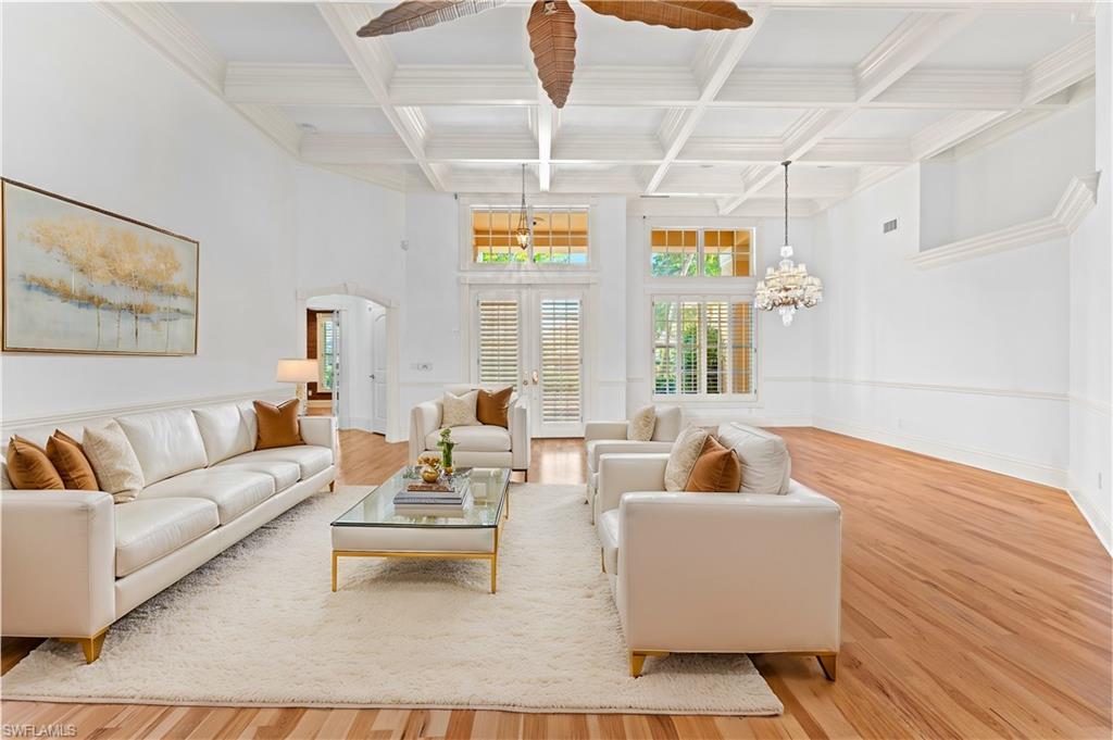 7126 Mill Run Road Naples, FL 34109 - Photo 6 of 49 Living room with a chandelier, hardwood / wood-style flooring, beamed ceiling, and coffered ceiling