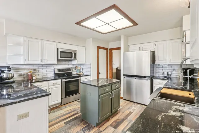 a kitchen with stainless steel appliances granite countertop a refrigerator stove microwave and sink