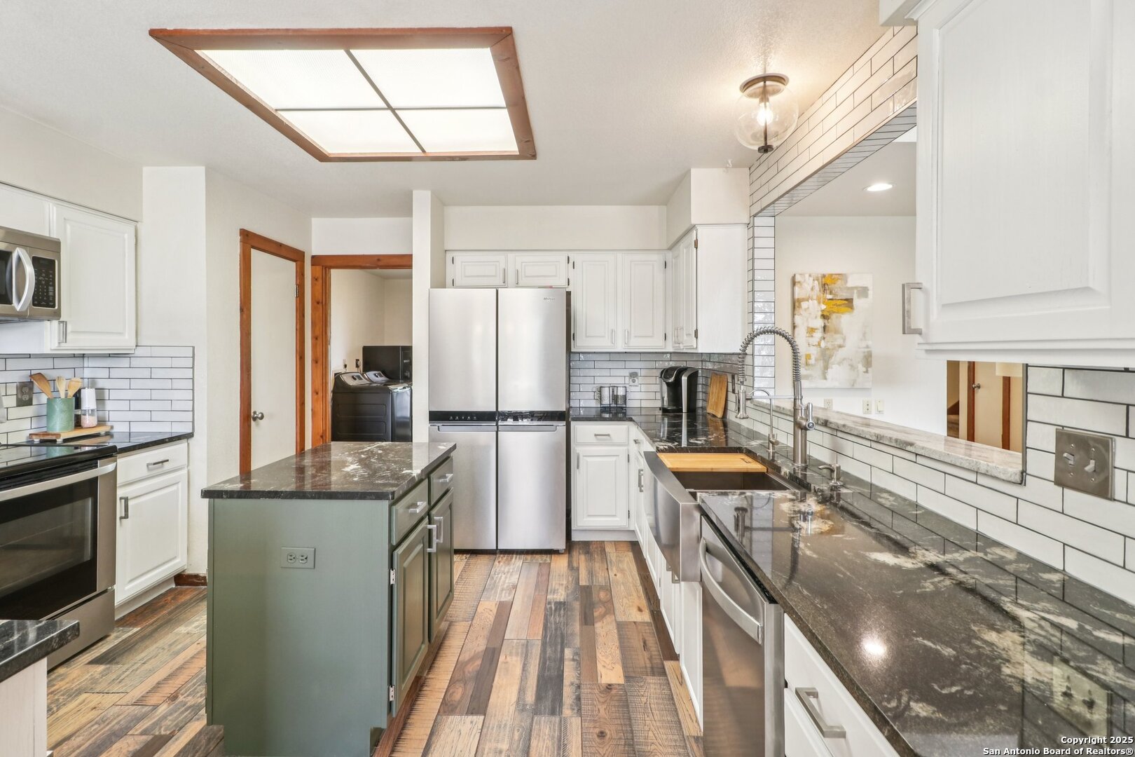 20211 County Road 174 Helotes, TX 78023 - Photo 19 of 45 a kitchen with stainless steel appliances granite countertop a refrigerator a stove top oven a sink dishwasher and couches with wooden floor