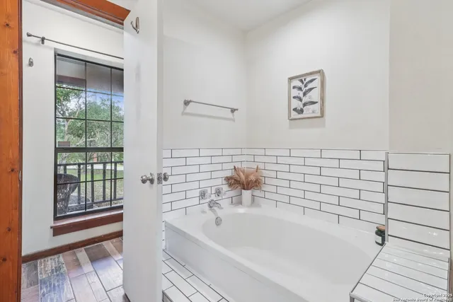 a bathroom with a bathtub and next to a window