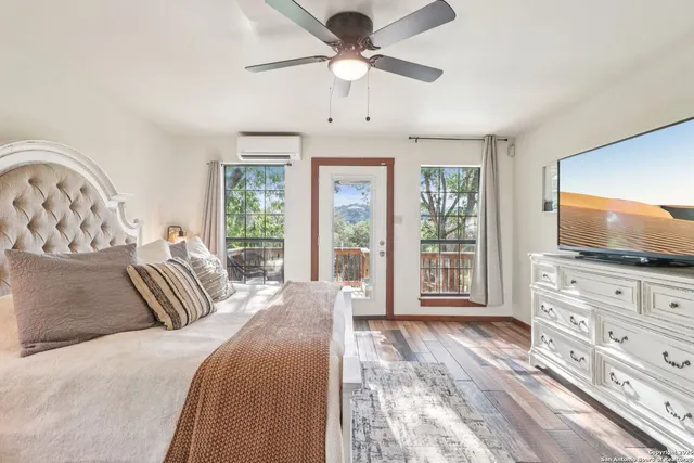 a bedroom with a large bed and a flat tv screen on dresser