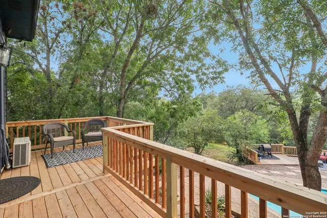a view of a balcony with wooden floor and fence