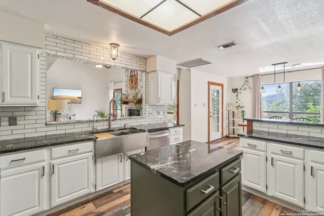 a kitchen with center island white cabinets and stainless steel appliances