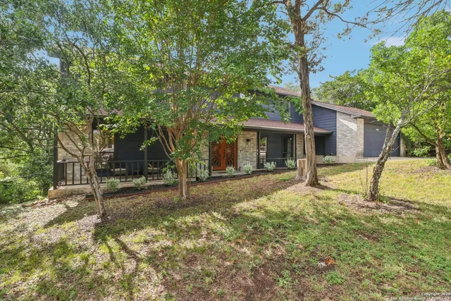 a view of a house with a backyard and a tree