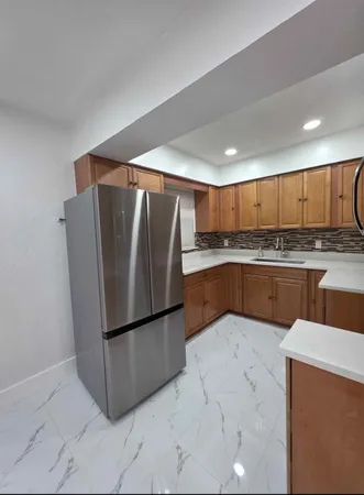 a kitchen with stainless steel appliances granite countertop a refrigerator sink and cabinets