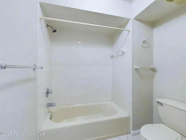 a white bath tub sitting next to a toilet