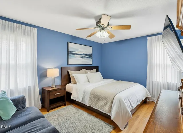a bedroom with bed and wooden floor